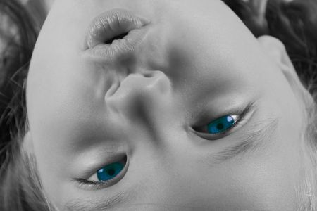 Upside Down - pretty little girl with bright blue eyes.  Black and white image with blue eyes.の写真素材