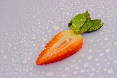 Fresh strawberry slice with water droplets - a delicious and nutritious snack.の写真素材