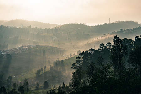 A sunrise view from Ooty hills with dramatic sky with warm sunlight and beautiful landscapeの写真素材