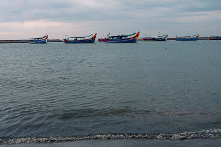 Fishing boats docked in the harbor during the sunset and blue hour
