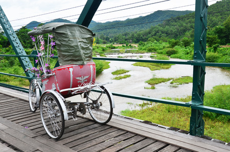 Tricycle thai style on Bridge over Pai River at Pai at Mae Hong Son Thailandの写真素材