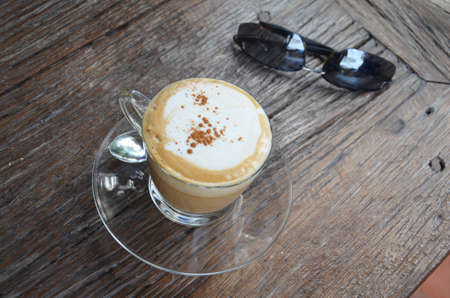 Hot Coffee with Sunglasses on Tableの写真素材
