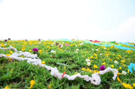 Wind with Colored papers placed on a grave during Qingming Festival at Sritasala Cemetery in Ratchaburi, Thailand.の写真素材