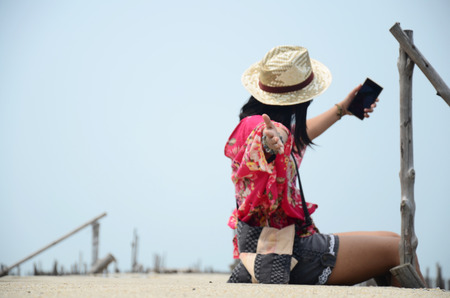 Thai women selfie by mobile phone on the walkway bridge in Mangrove forest or Intertidal forest at Bangkhunthein in Bangkok Thailand.の写真素材