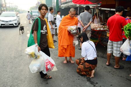 People put food offerings in a Buddhist alms bowl at Bangyai small market on April 12, 2015 in Nonthaburi Thailand.のeditorial素材