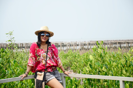 Thai women standing alone on the walkway bridge in Mangrove forest or Intertidal forest at Bangkhunthein in Bangkok Thailand.のeditorial素材