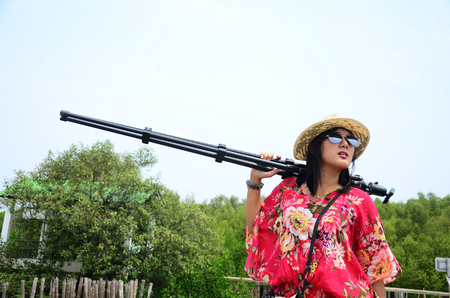Thai woman portrait with tripod on the bridge in Mangrove forest or Intertidal forest at Bangkhunthein in Bangkok Thailand.の写真素材