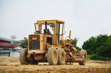 Motor grade Machine and people working at construction site