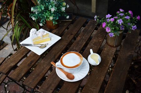 Hot Coffee and Coconut Cake on table in garden of coffee shopの写真素材
