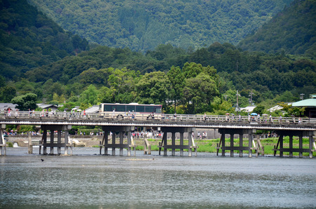 People and transport use Togetsukyo Bridge across the Oi River at Arashiyama on July 12, 2015 in Kyoto, Japanのeditorial素材