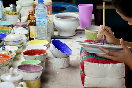 Thai people woking process paint Ceramic Benjarong is traditional thai five basic colors style pottery at workshop on August 8, 2015 in Samutsakhon, Thailand.のeditorial素材