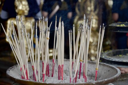 Thai people pray with flower, joss stick and candle for Buddha statue at Wat Yai chaimongkol in Ayutthaya, Thailandのeditorial素材