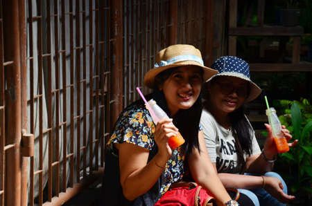 Thai woman and old women sit and drink at Koh Kret Island on November 21, 2015 in Nonthaburi, Thailand.のeditorial素材