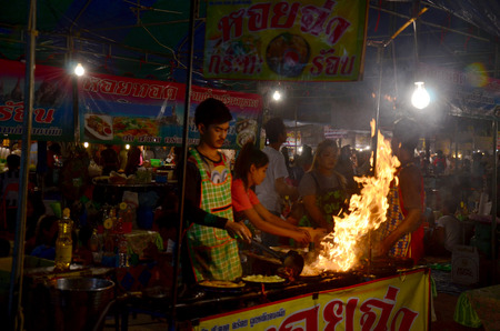 Thai people cooking Fried mussel with egg and crispy flour or Oyster omelette for sale people in market fair in annual festival of Wat Lam Pho on February 6, 2015 Nonthaburi, Thailand.のeditorial素材