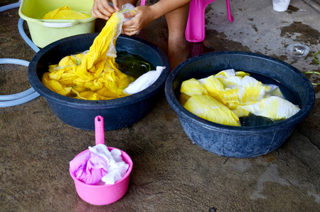 Thai women washing and clean clothes after tie batik dyeing natural color at Nonthaburi, Thailand.の写真素材