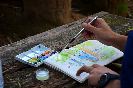 Thai people draw watercolor painting on paper at Kaeng Krachan largest national park on October 23, 2015 in Phetchaburi, Thailand.の写真素材