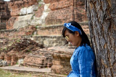 Thai women portrait with tree at ancient building at Wat Mahathat in Ayutthaya, Thailandの写真素材