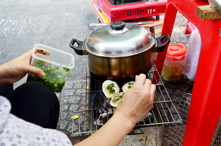 Vietnmese people cooking shell for sale on street at Saigon city on January 22, 2016 in Ho Chi Minh, Vietnamのeditorial素材