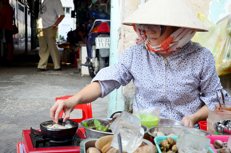 Vietnmese people cooking shell for sale on street at Saigon city on January 22, 2016 in Ho Chi Minh, Vietnamのeditorial素材
