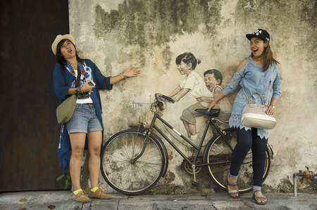 Thai woman portrait with painting on the wall at Street art of George Town on April 24, 2016 in Penang, Malaysiaのeditorial素材