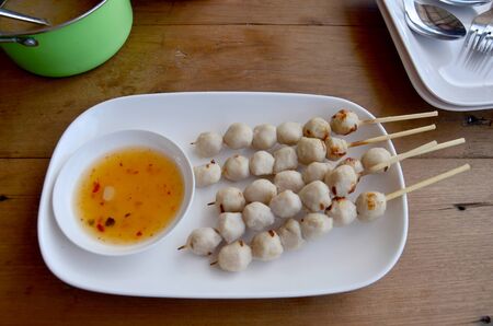 Skewers of pork balls or pork meatballs grilled thai style serve with sweet sauceの写真素材