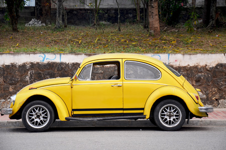 Classic retro yellow car Volkswagen Beetle on the road on April 8 , 2016 in Luang Prabang, Laosのeditorial素材