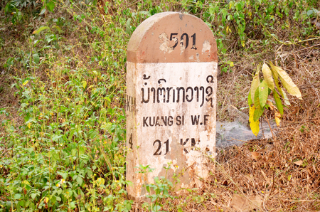 Old Milestone on the road information distance to Kuang Si Falls or Tat Kuang Si Waterfalls on April 8, 2016 in Luang Prabang, Laosのeditorial素材