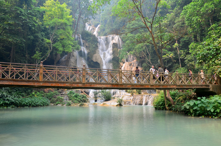 People on bridge looking and take photo with viewpoint of Kuang Si Falls or Tat Kuang Si Waterfalls on April 8, 2016 in Luang Prabang, Laosのeditorial素材