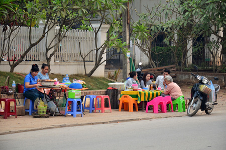 Local restaurant of Laotian people sale and eat food on street at local night market on April 7, 2016 in Luang Prabang, Laosのeditorial素材