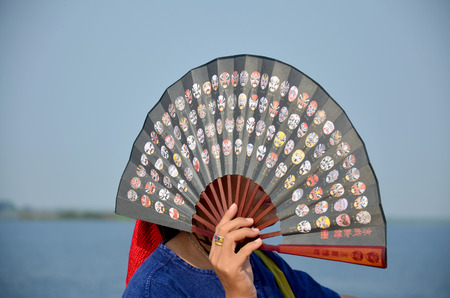 Thai people waving wooden fans on boat go to Donsawan island at Nong Han lake on January 15, 2016 in  Sakon Nakhon, Thailandの写真素材