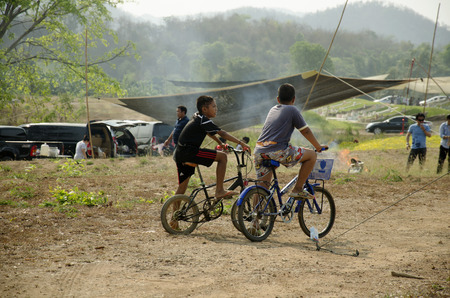 Thai children biking bicycle at Sritasala Cemetery Chinese grave at the Qingming Festival day in Ratchaburi,Thailandのeditorial素材
