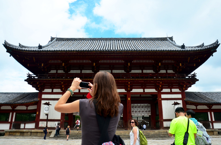Traveler woman foreigner use smart phone shooting photo Todai-ji Temple on July 9, 2015 in Nara, Japanのeditorial素材