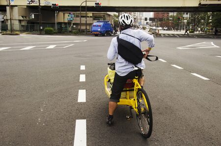 Japanese people riding new innovation bicycle  waiting traffic sign for walk crosswalk traffic road junction go to work near Tokyo tower on October 21, 2016 in Tokyo, Japanのeditorial素材