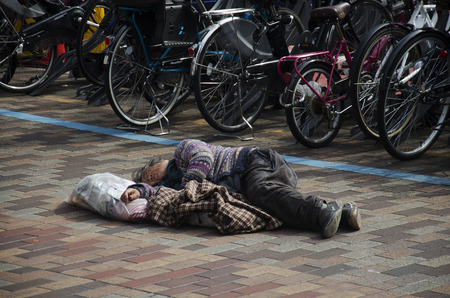 Japanese vagabond people sleeping on floor in public park in morning time at shinjuku district on October 21, 2016 in Tokyo, Japanのeditorial素材