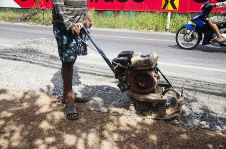 Thai people use soil compactors in construction site working and repair surface of road at  rural roads countrysid on November 27, 2016 in Nonthaburi, Thailandのeditorial素材