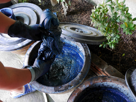 Thai men tie batik dyeing Indigenous Knowledge of Phrae people is Chemical and liquid dye Mauhom color in pot of Traditional clothes Kind of fashion in Northern Thailand  at Nonthaburi, Thailand.の写真素材