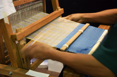 Thai people using small loom or weaving machine for weaving show traveller in Ayutthaya, Thailandの写真素材
