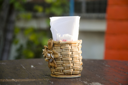 Rattan weave Box of tissues and toothpick on wooden table at hotelの写真素材