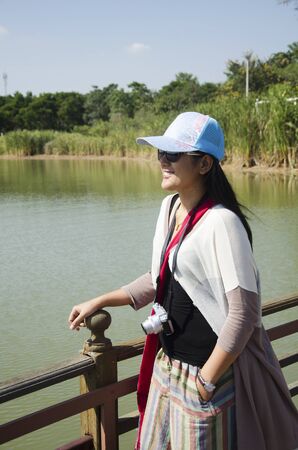 Asian thai woman posing and travel looking crocodiles at Bueng Boraphet public park in Nakhon sawan, Thailandのeditorial素材