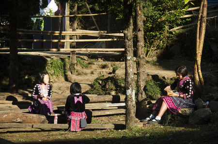 Children girl Ethnic Hmong wear costume traditional and sitting eat breakfast with friends at Doi Pui Tribal Village on December 28, 2016 in Chiang Mai, Thailand.のeditorial素材