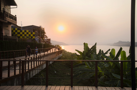Travelers people take photo at riverside of Mae Khong river with reflection of sun in sunset time at Chiang Khan on February 21, 2017 in Loei, Thailand.のeditorial素材