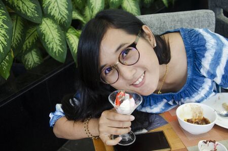 Thai woman show sweet dessert before eat at food buffet service in restaurant of Hotel in Thailandの写真素材