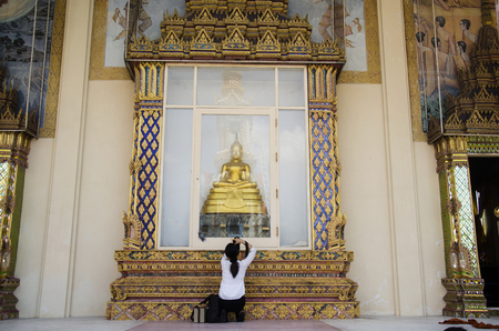 Thai women photographer shooting photo buddha statue at front of ubosot of Wat Wachirathammasatit or wat thung satit temple on February 19, 2017 in Bangkok, Thailandのeditorial素材