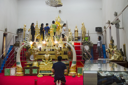 Thai people respect praying and gild cover with gold leaf on Luang Pho Ban Laem statue at Wat Phet Samut Worawihan on April 12, 2017 in Samut Songkhram, Thailandのeditorial素材