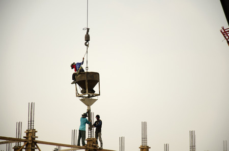 Asian thai workers working with heavy machinery automobile crane for new building at construction site high-rise building at capital city on May 14, 2016 in Nonthaburi, Thailand.のeditorial素材