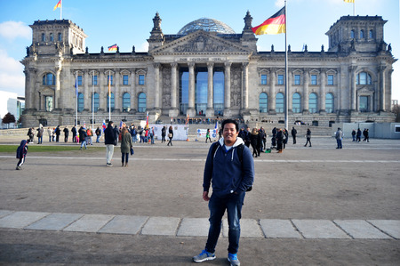 Thai man traveler visit and posing for take photo at front of Reichstag building is historic edifice at Berlin city on November 9, 2016 in Berlin, Germanyのeditorial素材