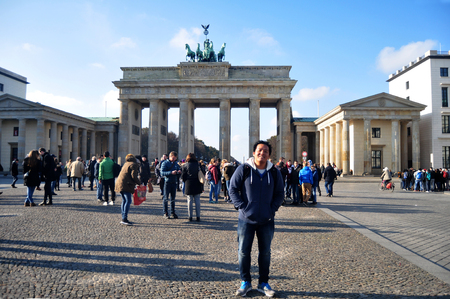 Thai man visit and posing for take photo at front of Brandenburg Gate is 18th-century neoclassical monument and icon of Berlin on November 9, 2016 in Berlin, Germanyのeditorial素材