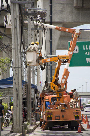 Electrician worker of Metropolitan Electricity Authority working repair electrical system on electricity pillar or Utility pole on August 9, 2017 in Nonthaburi, Thailandのeditorial素材