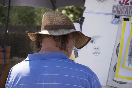 Czechia men service been painted portraits and caricatures and drawing watercolor painting at Charles Bridge on August 30, 2017 in Prague, Czech Republicのeditorial素材