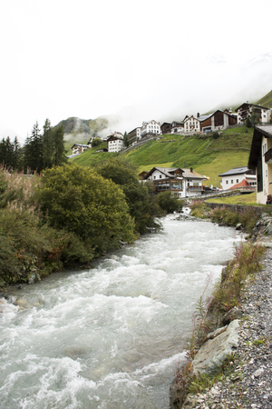 Stream and Glacier from Alps highest and most extensive mountain range flowing passed at Villages of Tschlin and Ramosch near Samnaun a high Alpine village at Graubunden region of Switzerlandのeditorial素材